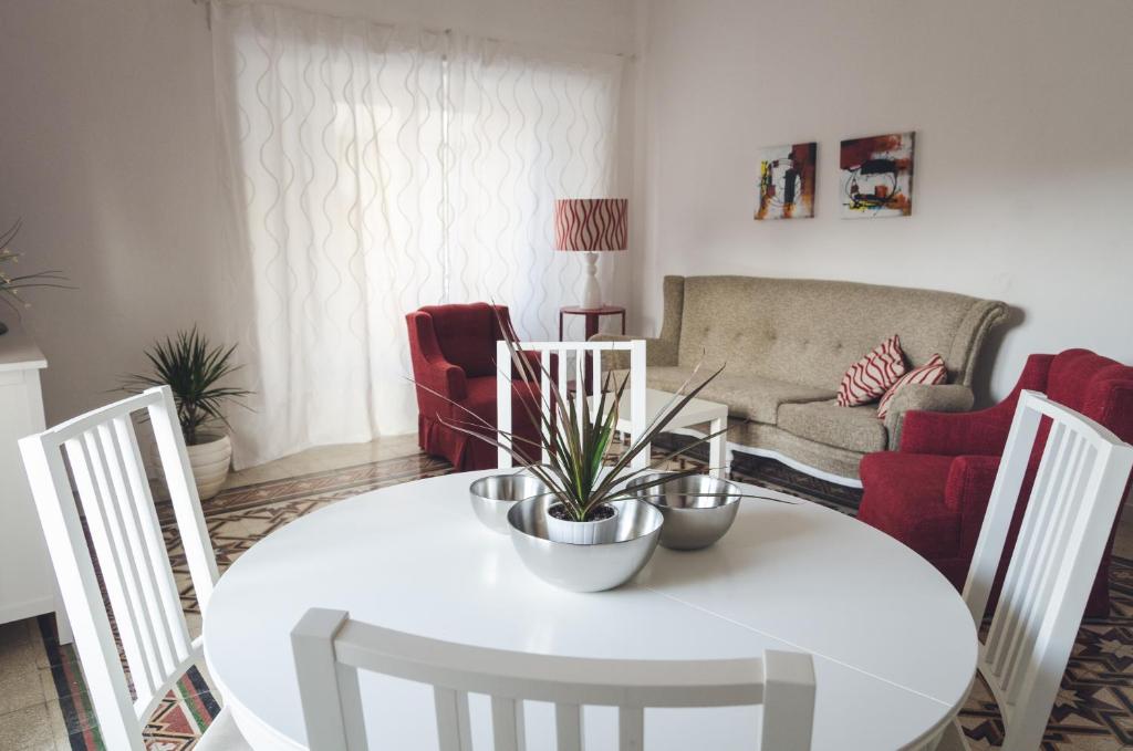 ein Wohnzimmer mit einem weißen Tisch und Stühlen in der Unterkunft Casa Diaz in Syrakus