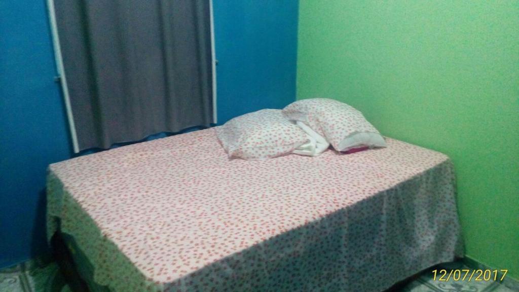a bed with two pillows on top of it at pousada ondas do atlântico in Salinópolis