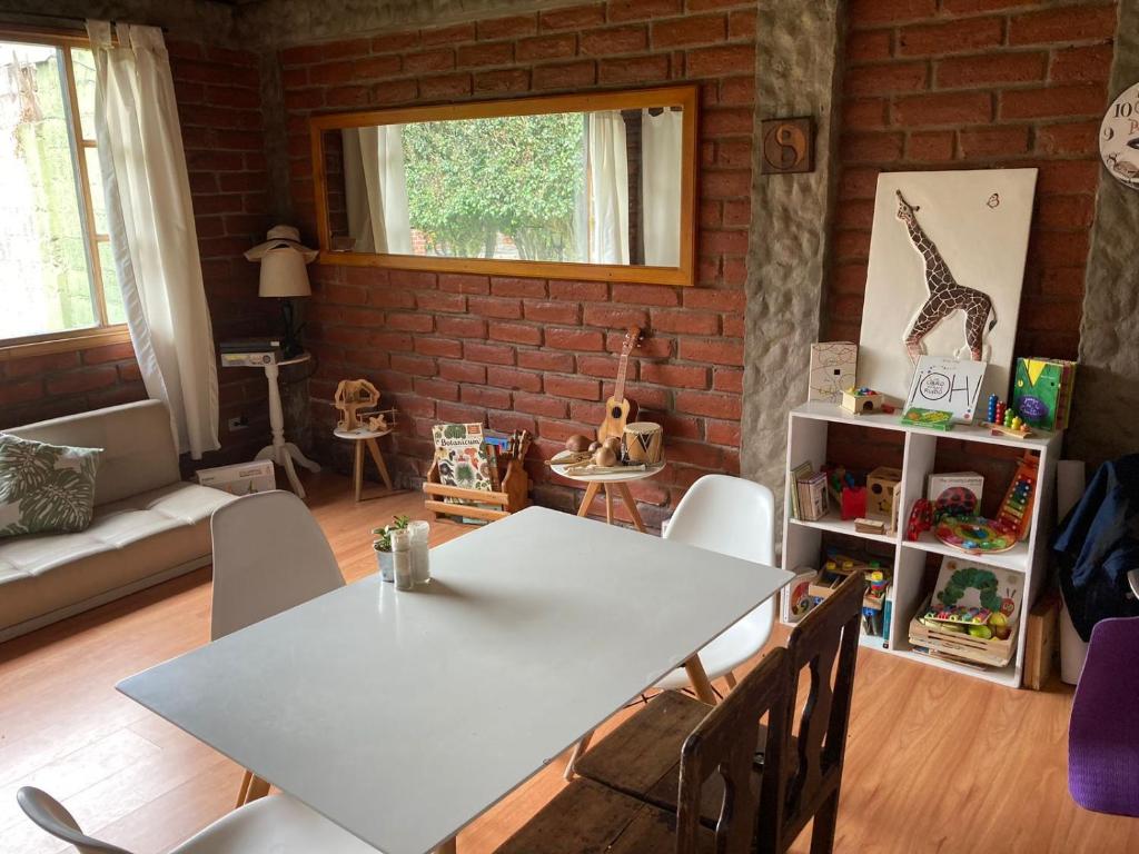 a dining room with a white table and chairs at Great Hostels Backpackers in Baños
