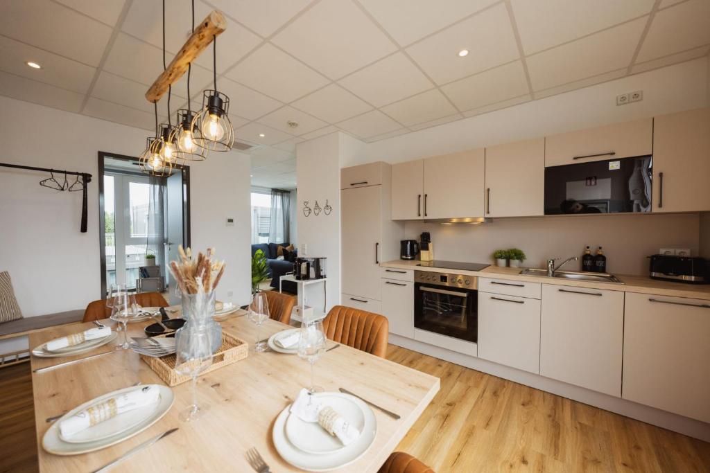 a kitchen and dining room with a wooden table at HYGGE HOMES Apartment 'Scandi Sunset' in Winsen