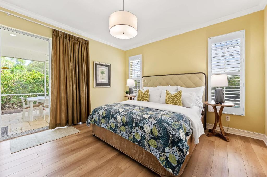 a bedroom with a bed and a balcony at Neapolitan Vacation Rentals - Pet Friendly, Newly Updated Luxury Home with Private Pool! Complete Privacy and Only a 10 Minute Walk to Vanderbilt Beach Close to Mercato and the Best of Naples in Naples