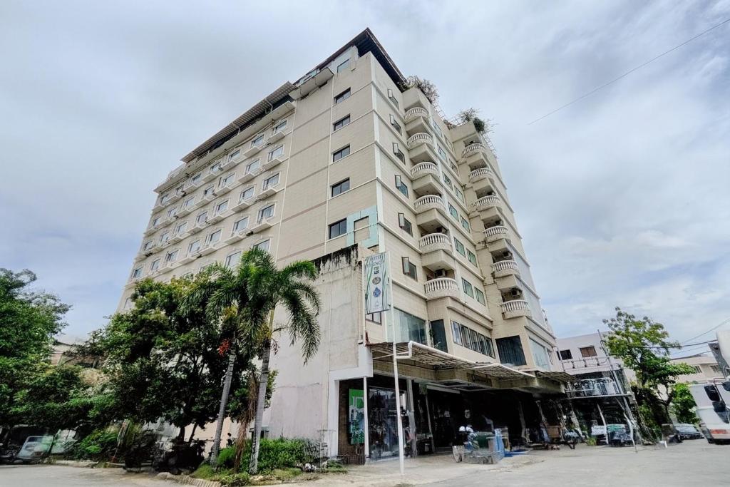 ein hohes Gebäude mit einer Palme davor in der Unterkunft Hotel Essencia in Dumaguete