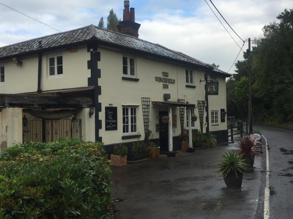 a white building with a gate in front of it at The Winchfield Inn in Winchfield