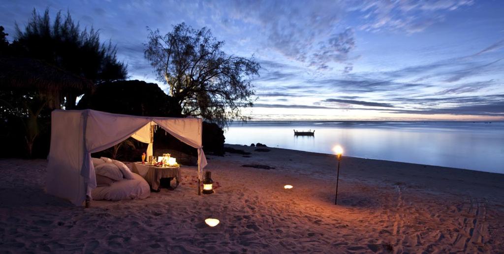 a tent on a beach with a table and candles at Maras Marinas Home in Nikiti