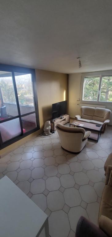 a large living room with a couch and a tv at Colocation Du Grand Large in Décines-Charpieu