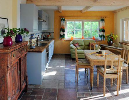 eine Küche und ein Wohnzimmer mit einem Tisch und einem Sofa in der Unterkunft Landgut Jungbrunnen in Glashagen