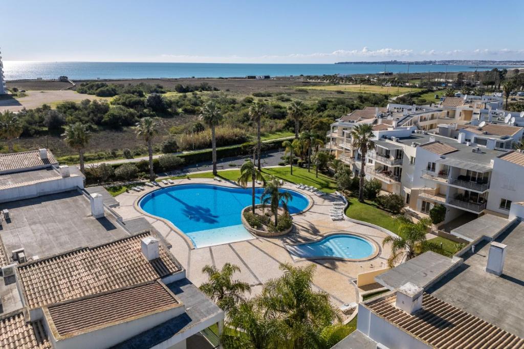 an aerial view of a resort with a pool and the ocean at Vila da Praia by ALgest in Alvor