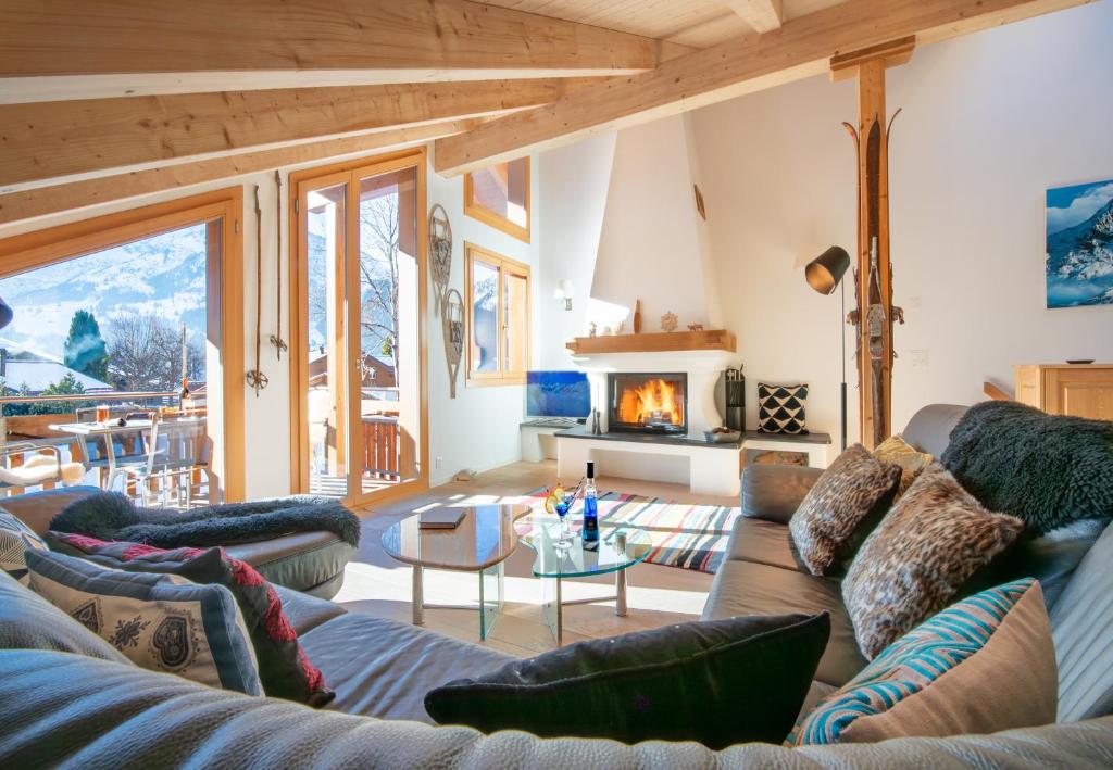 a living room with a couch and a fireplace at Chalet Stella Penthouse Residence in Wengen