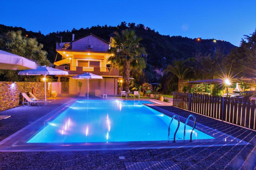 a swimming pool in front of a house at night at Villa Verde in Lefkada