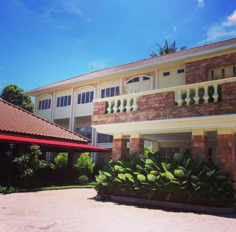 a building with a bunch of green plants in front of it at Nina Hotel Syariah in Salatiga