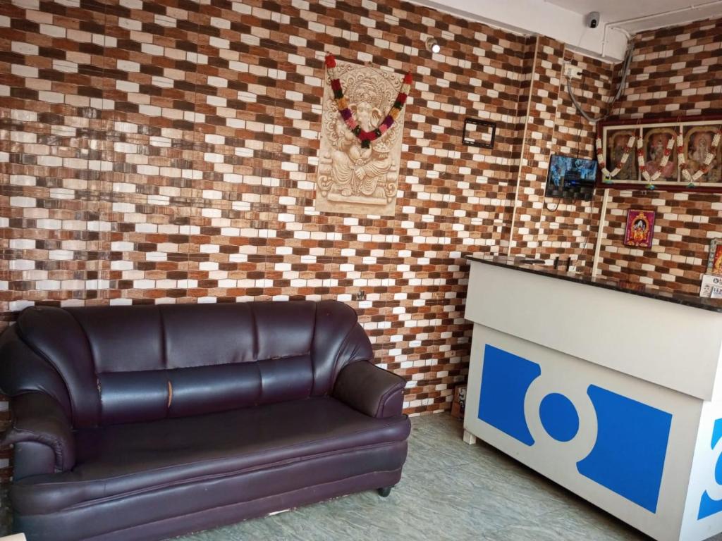 a leather couch in a room with a brick wall at ComfortInn in Chennai