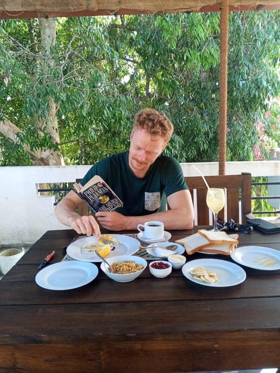 a man sitting at a table with plates of food at JO Residence - Tangalle in Tangalle