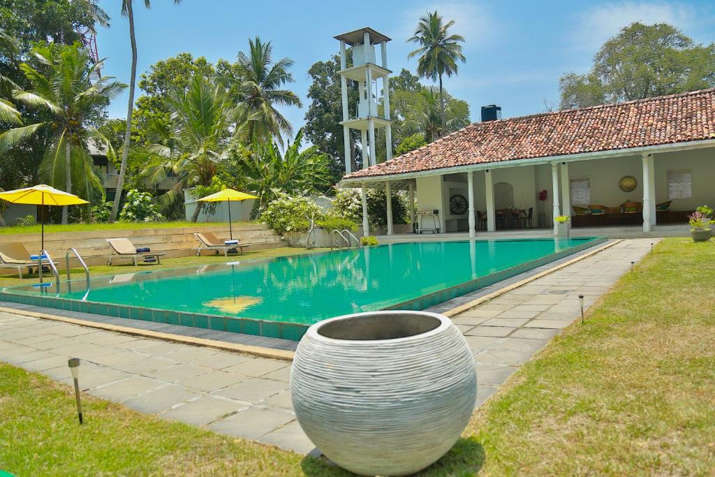 a villa with a swimming pool and a house at White House Tangalle in Tangalle