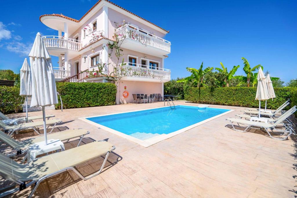 a villa with a swimming pool in front of a house at Villa Zante Odysseus in Planos