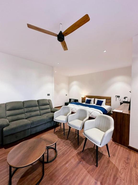 a living room with a couch and a bed at Hulara Meadows in Lucknow