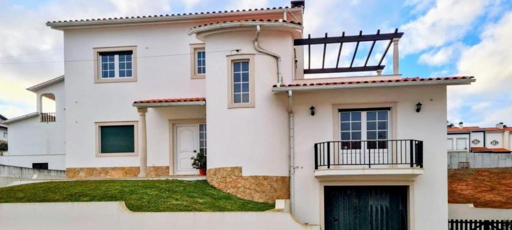 a white house with a balcony on top of it at Casa Lu in Salir de Porto