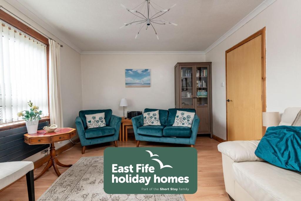 a living room with a couch and two chairs at Seascape Apartment - Crail in Crail