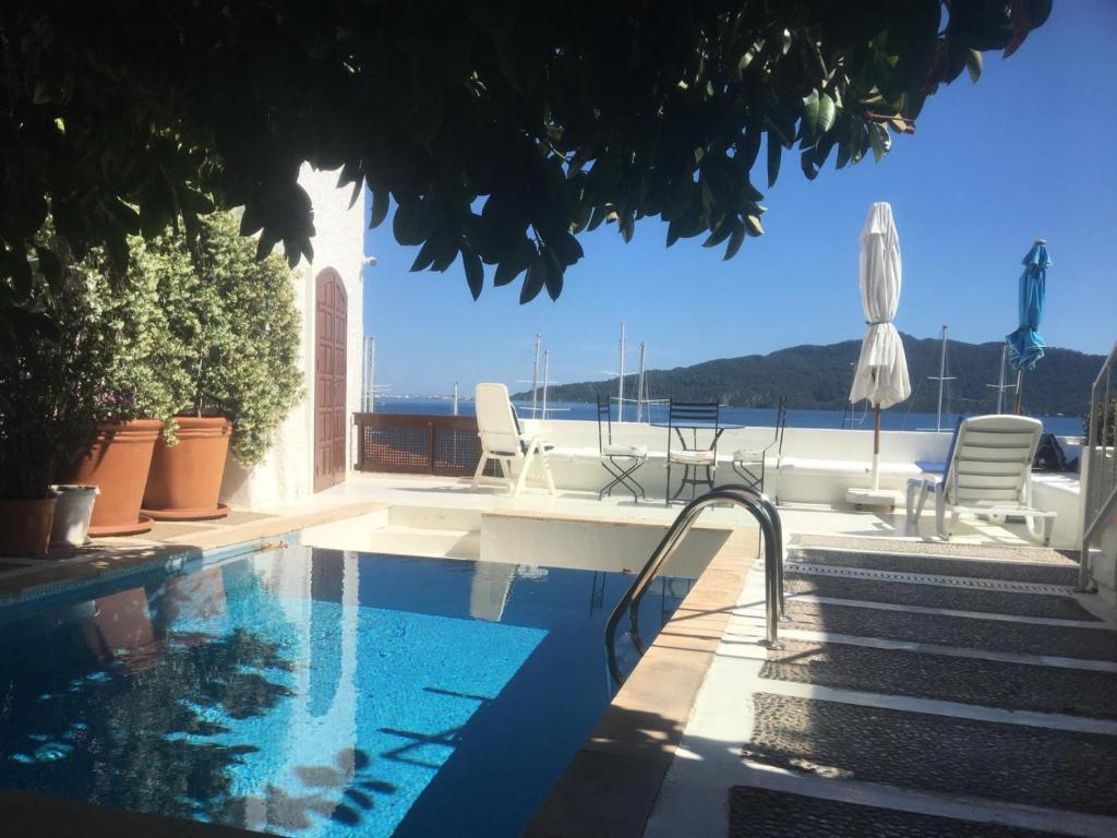 a swimming pool with two chairs and an umbrella at Castle81homes Blue - Sea view house in Marmaris