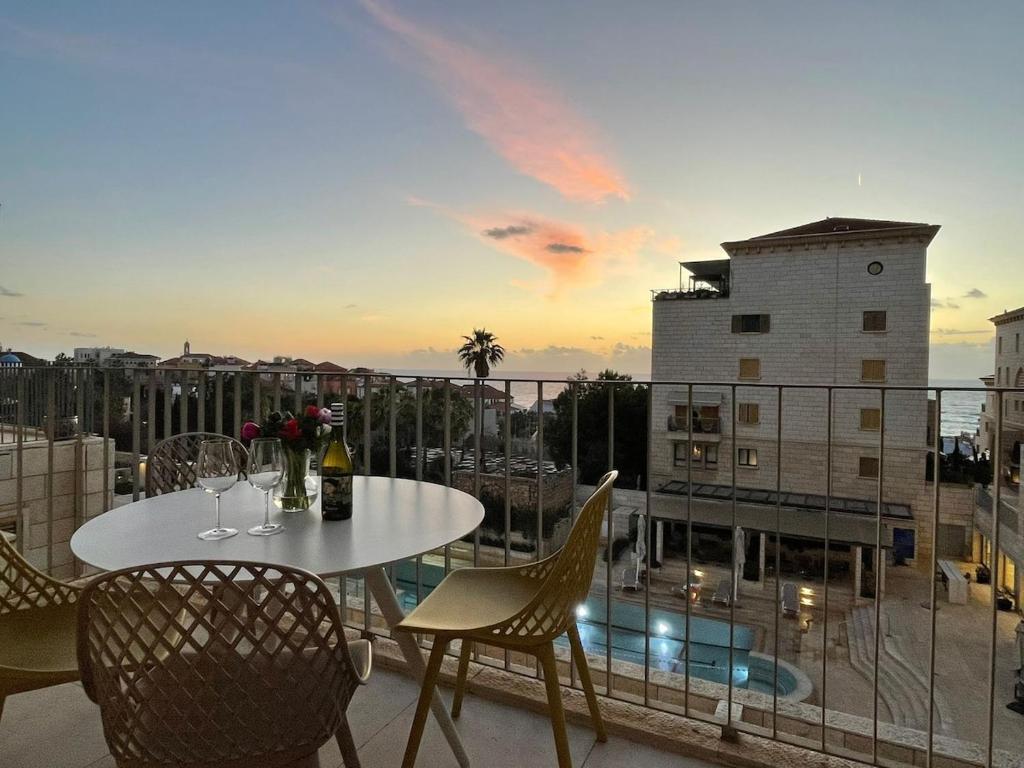 a table and chairs on a balcony with a view at Andromeda Sunset Suite & Spa in Tel Aviv