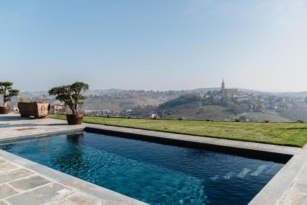 a swimming pool with a hill in the background at LVguesthouse in Priocca