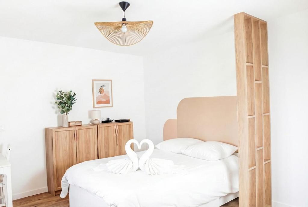 two swans sitting on a bed in a bedroom at Chic Home - Turckheim in Turckheim