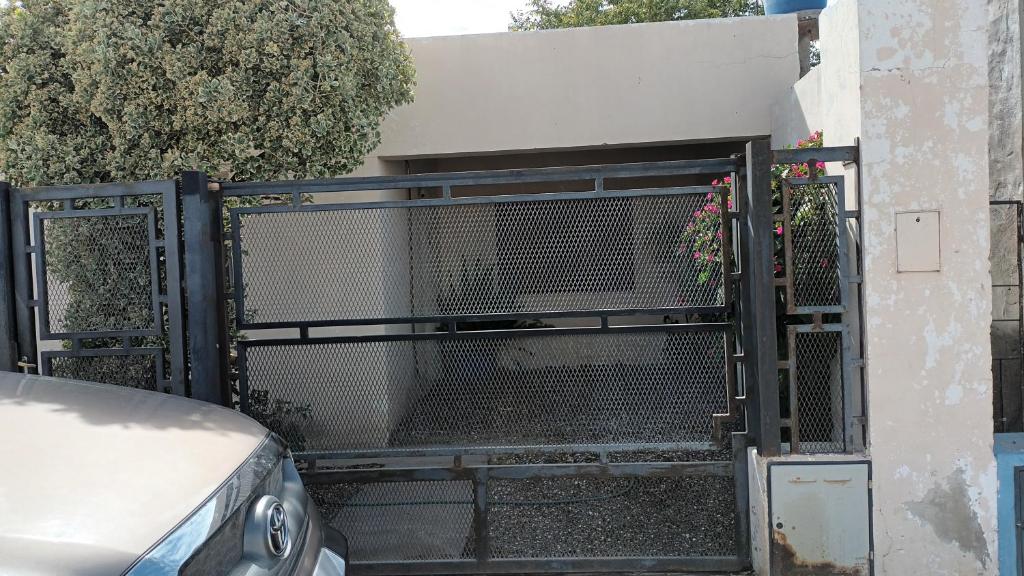 a black gate with a plant on the side of a building at Ester in San Antonio Oeste