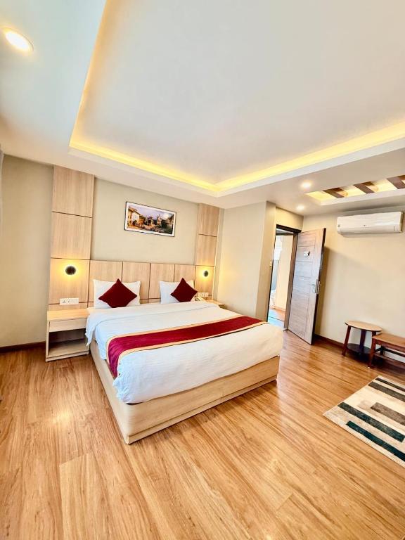 ein großes Schlafzimmer mit großem Bett und Holzböden in der Unterkunft Hotel Aerocity in Kathmandu