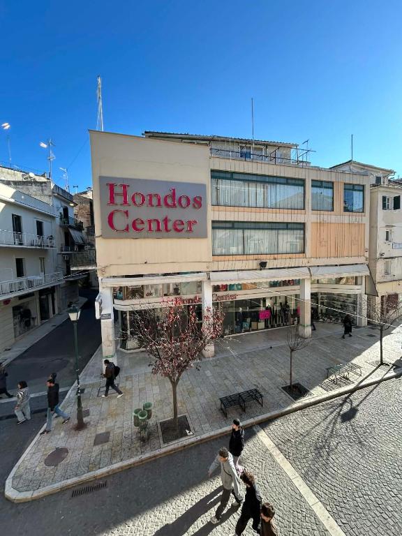 a large building with people walking in front of it at DORA'S APARTMENTS STUDIO 1 in Corfu