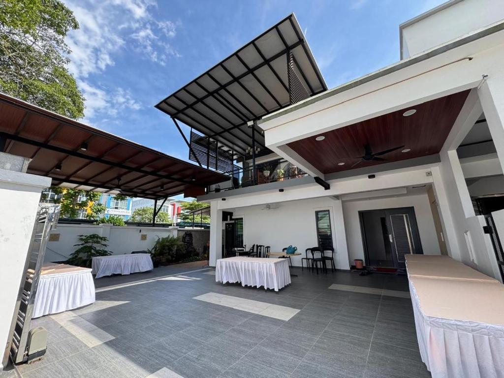 a patio with two tables and a building at Permas Jaya Corner Homestay -Event -Party -TablePool -Karaoke -BBQ in Johor Bahru