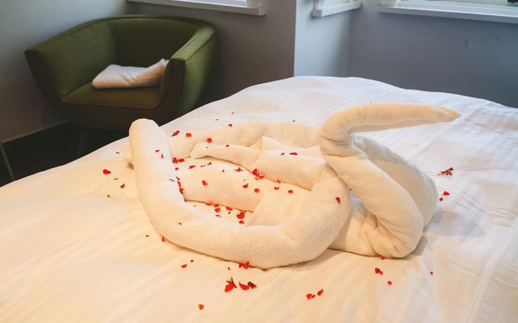 a towel animal shaped like a swan on a bed at Hill House butik in Istanbul