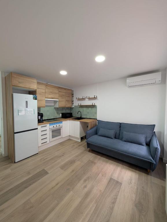 a living room with a blue couch in a kitchen at Bajo Alcobendas in Alcobendas