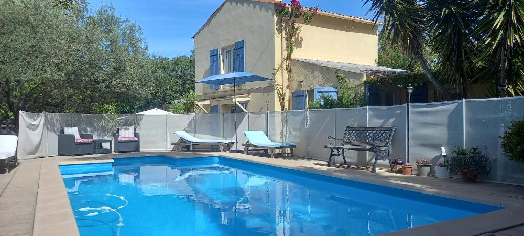 a swimming pool with two chairs and a house at Maison jardin grande piscine 2 étoiles in Marseille
