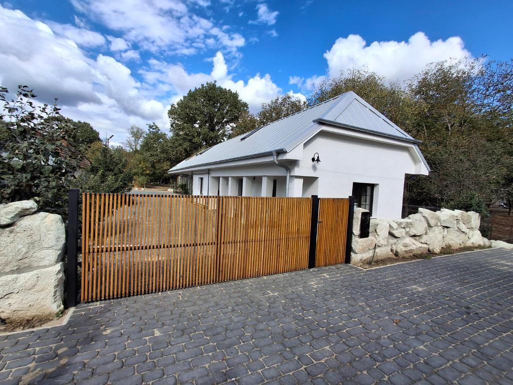 a white house with a fence in front of it at Merino vendégház in Tiszabecs