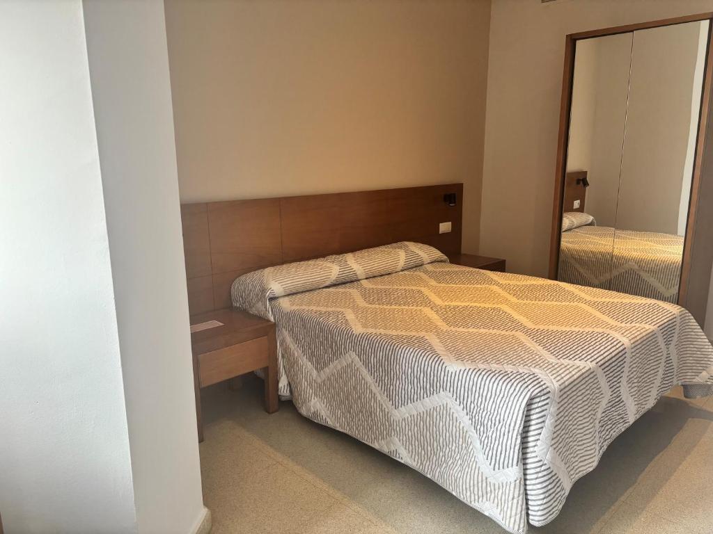 a bedroom with a bed and a mirror at Hostal La Isla in Montijo