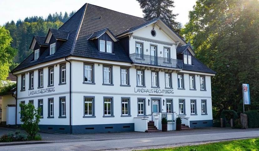 a large white building with a black roof at Landhaus Hechtsberg in Hausach
