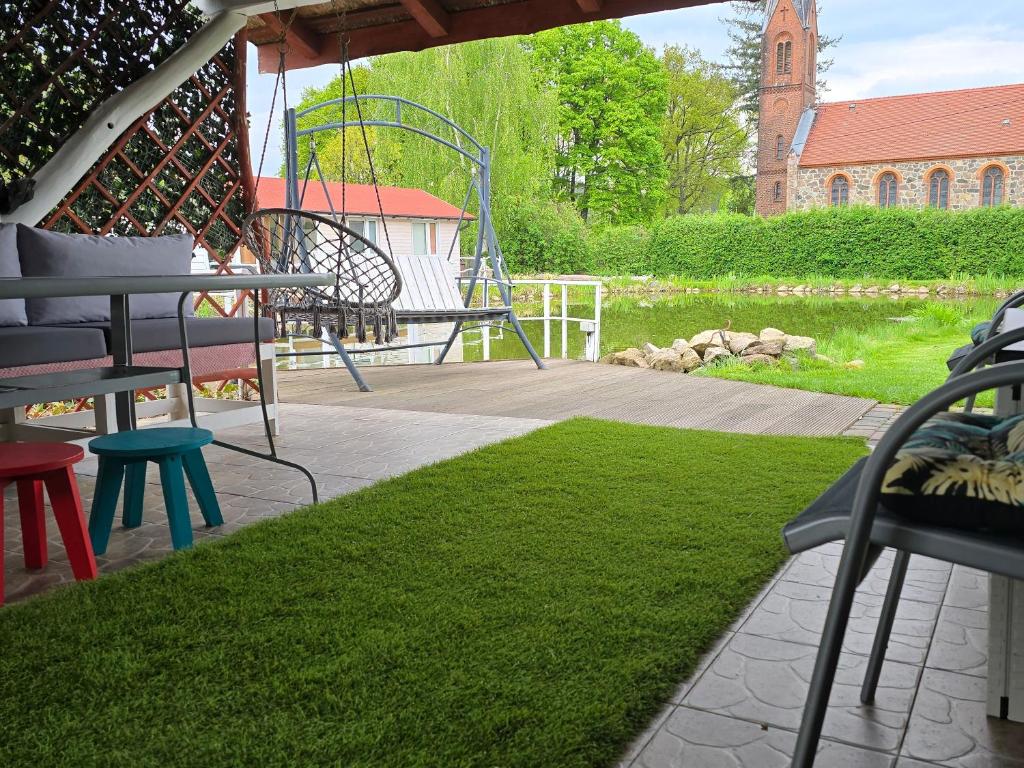 a patio with a table and chairs and a playground at Agroturystyka Nad Stawem in Sulęcin