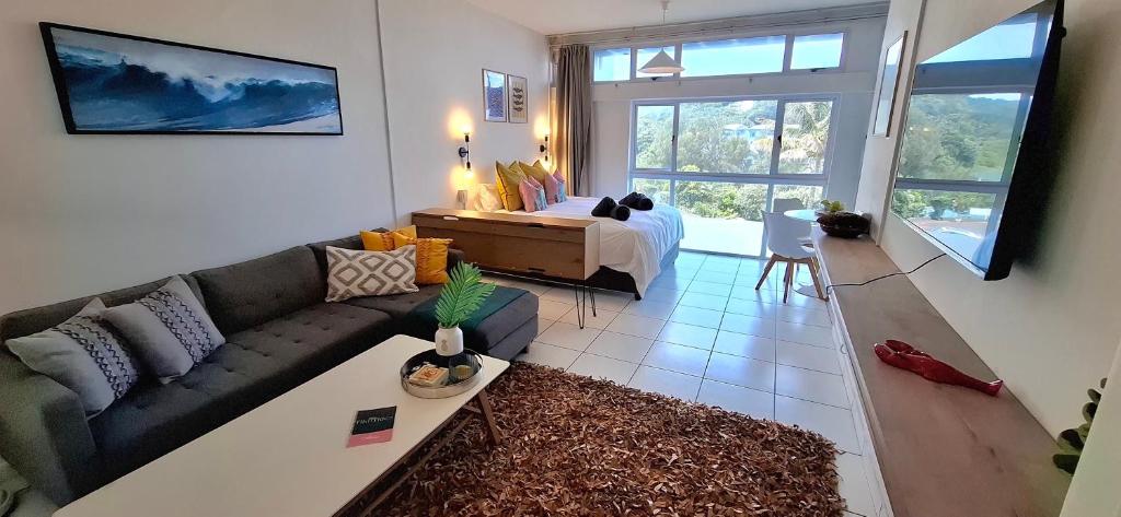 a living room with a couch and a bed at tiki tides in Umdloti