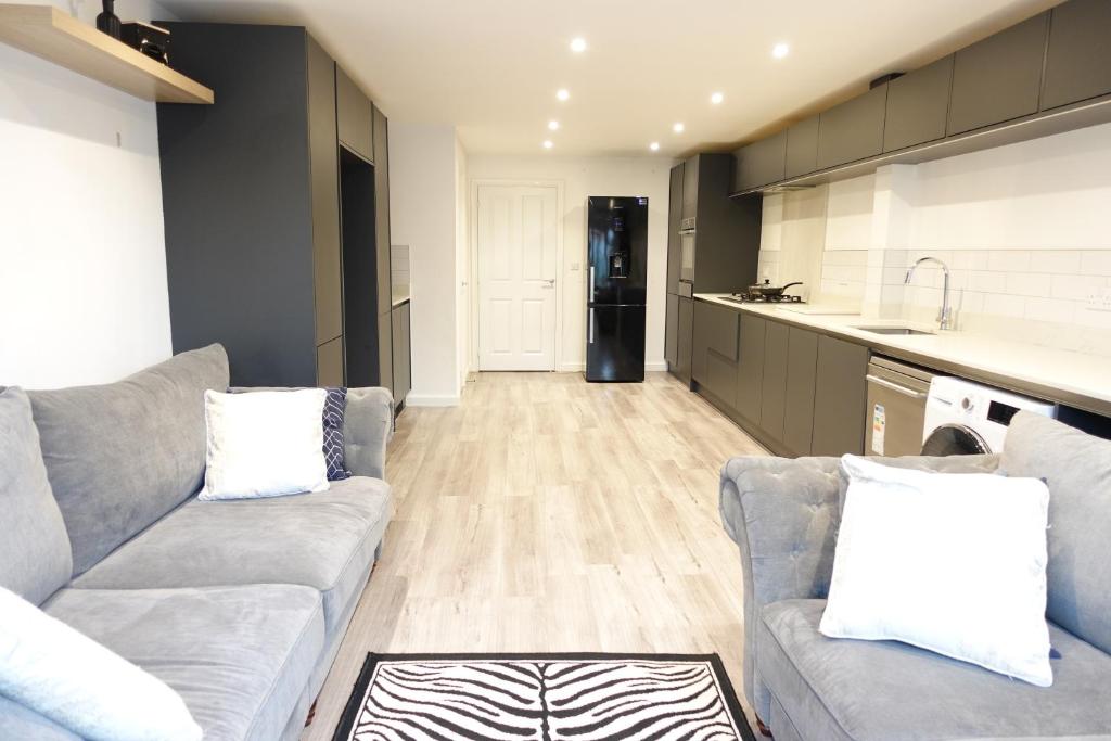 a living room with a couch and a kitchen at 4 bedroom, Sleeps 12, Free Parking in Corby and Weldon