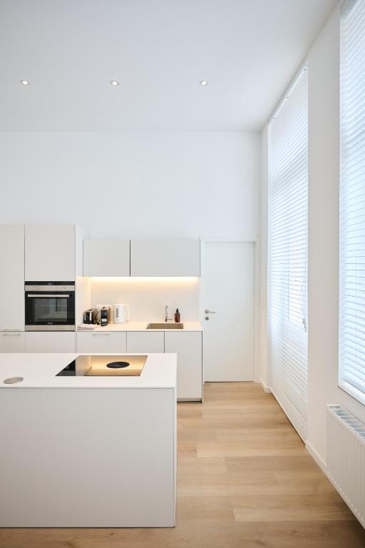 a kitchen with white countertops and white cabinets at Louise City 2 in Brussels