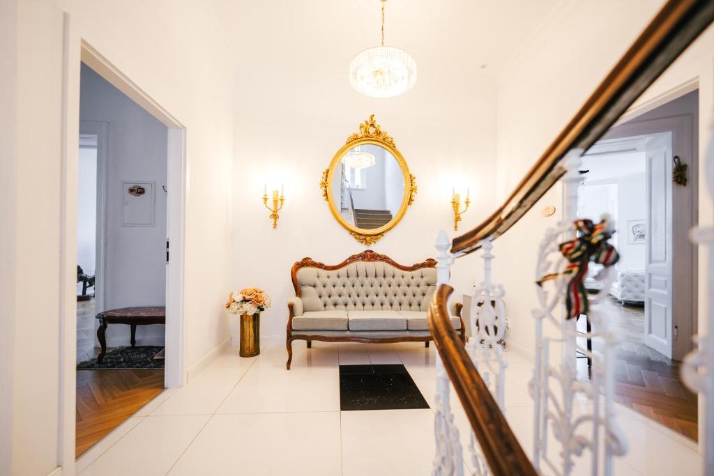 a living room with a chair and a mirror at Golf Apartment Villa Elisabeth in Mariánské Lázně