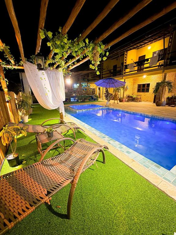 a bench next to a swimming pool at night at Pousada Praia do Amor Pipa in Pipa