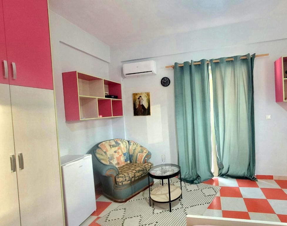 a living room with a chair and a table at Pinkapartment Saranda in Sarandë