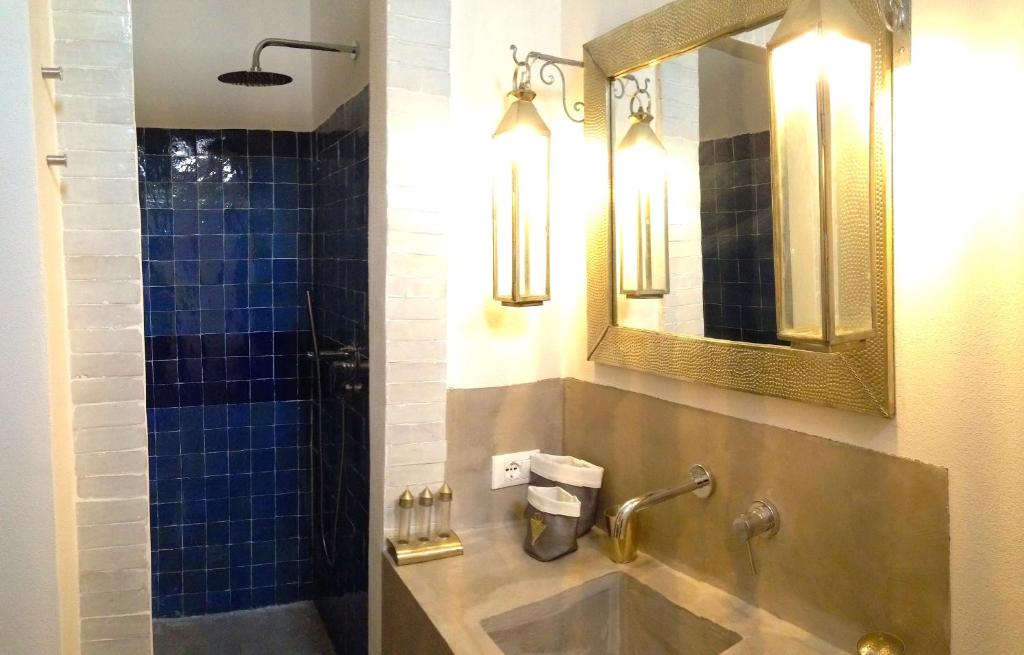 ein Bad mit einem Waschbecken und einer Dusche mit einem Spiegel in der Unterkunft Casa Sultana in Favignana