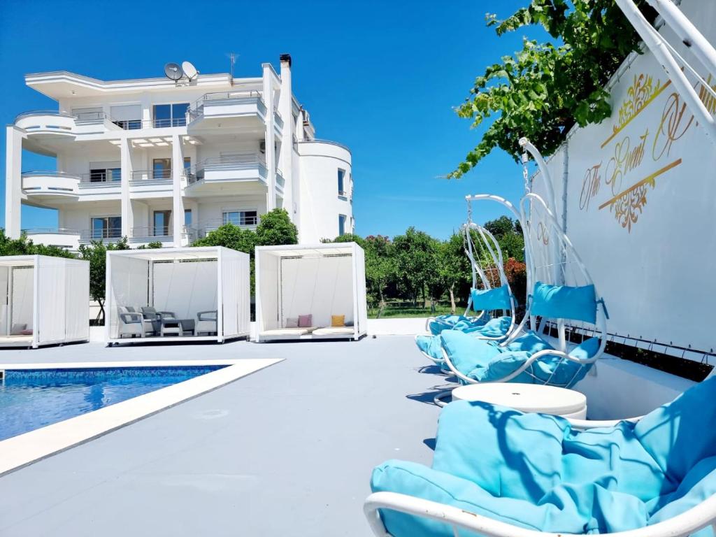 a pool with blue chairs next to a building at Le Domaine paradise in Briska Gora