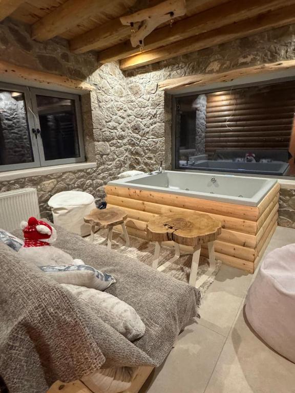 a bathroom with a tub in a stone wall at Cedar Wood Cabin in Áno Polídhrosos