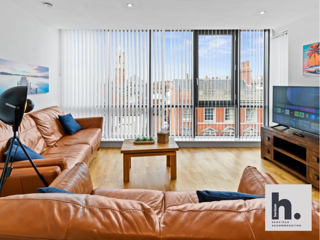 a living room with a leather couch and a tv at Contractors - Free Parking - City Centre - Balcony - x21 in Hull