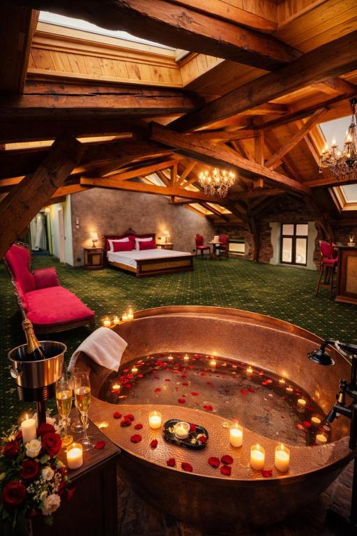 ein großer Raum mit einer Badewanne, in der Kerzen standen in der Unterkunft JMR Splendor - Private Sauna & Bathtub Suites in Constanţa