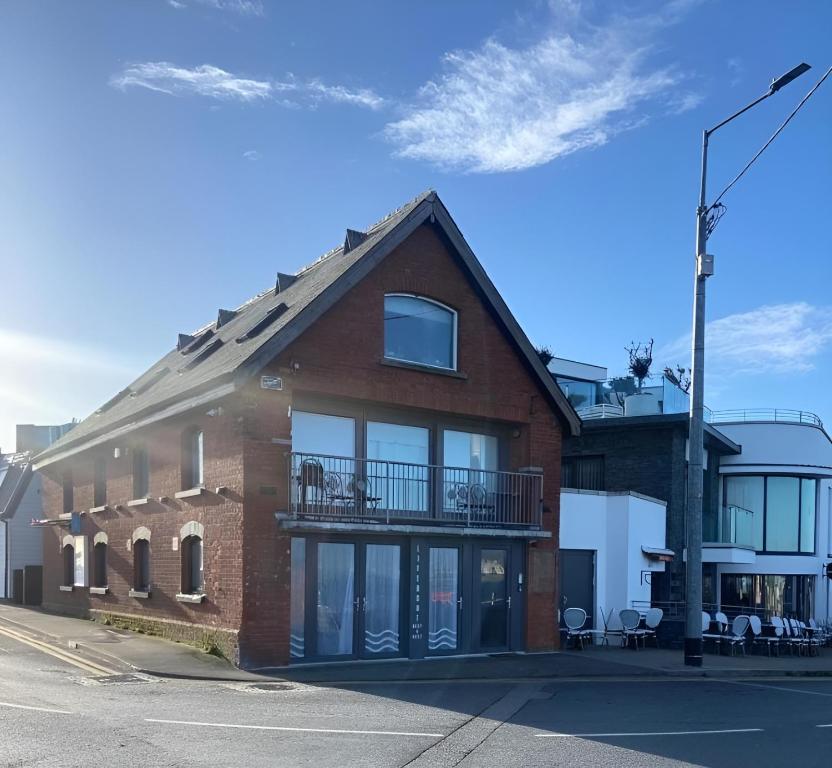 a brick building with a balcony on a street at Lifeboat House in Skerries