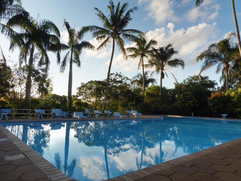 a swimming pool with palm trees in the background at HAPPY JUNGLE at 6 in St Lucia