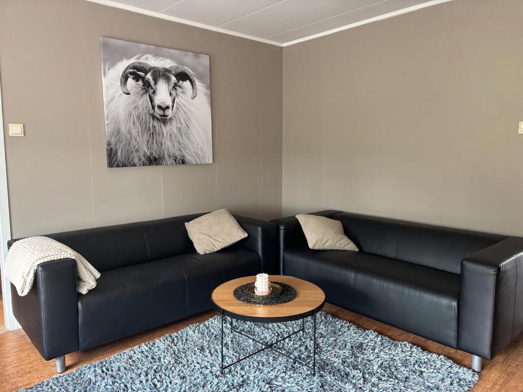 a black couch in a living room with a goat at Apartment in Senja in Senja
